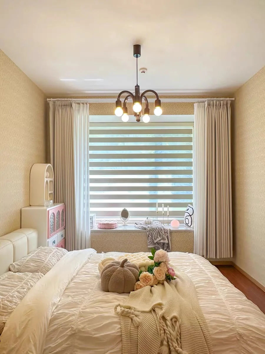 Bedroom window with alternating horizontal sheer and opaque pale bands; side curtains and bed also visible.