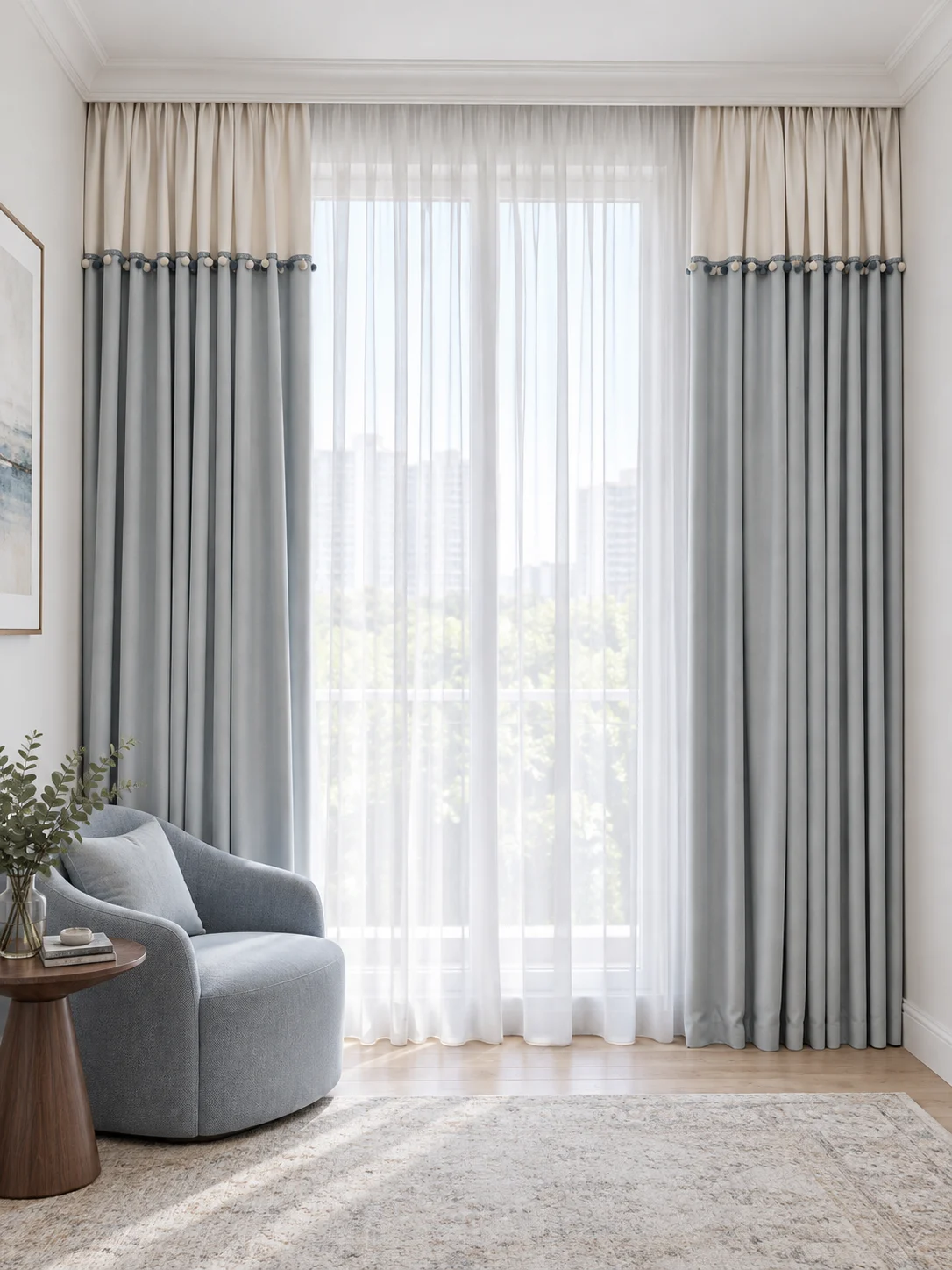 Curtain pair with ivory top fifth and dusty powder-blue long lower panels, narrow braided join carrying small alternating ivory and blue pom-poms, white full-height sheers behind. — full-window AI design visualisation.