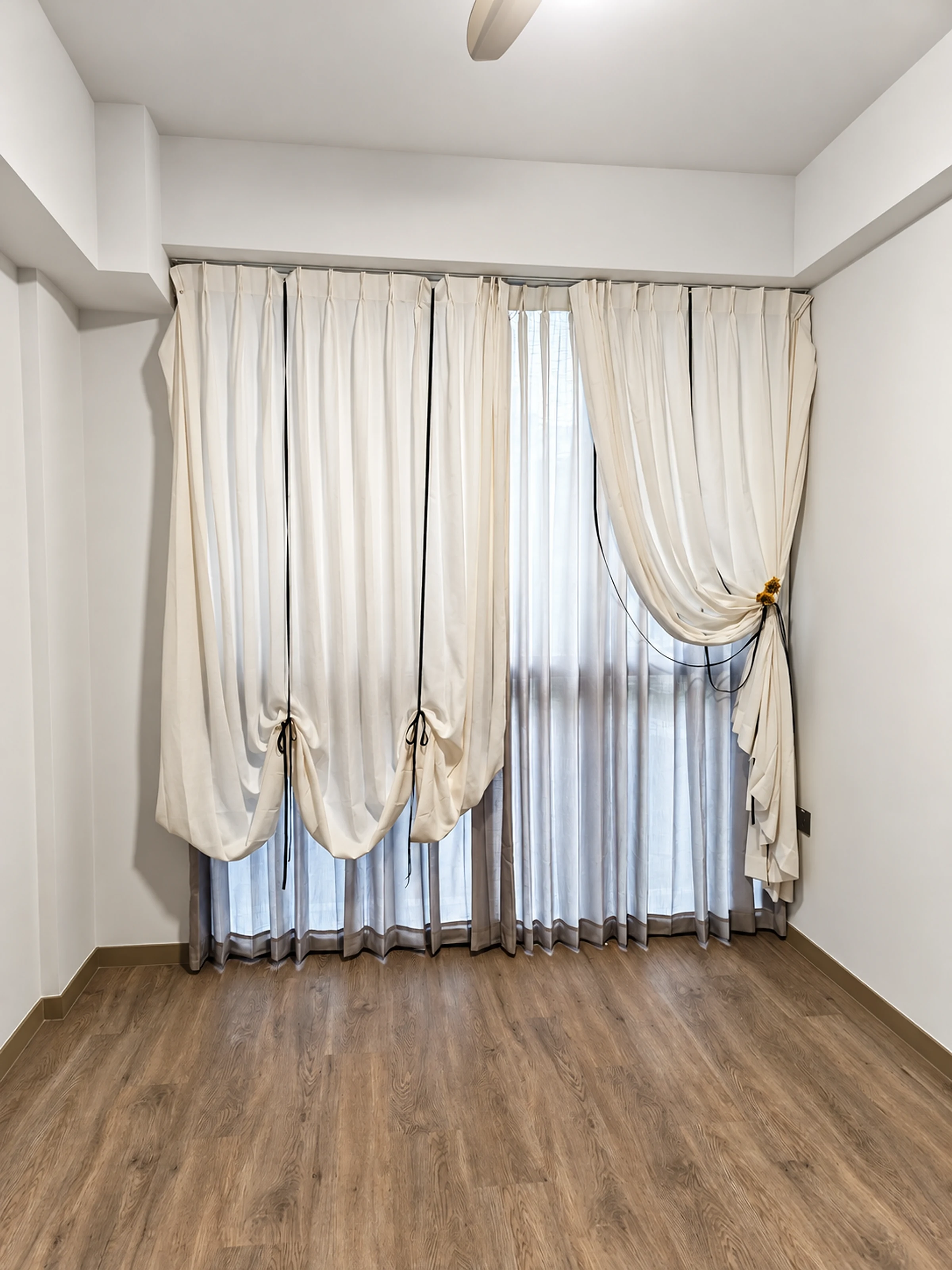 Floral tieback, ribbon & sweeping ivory folds — close-up of the supplied curtain photograph.