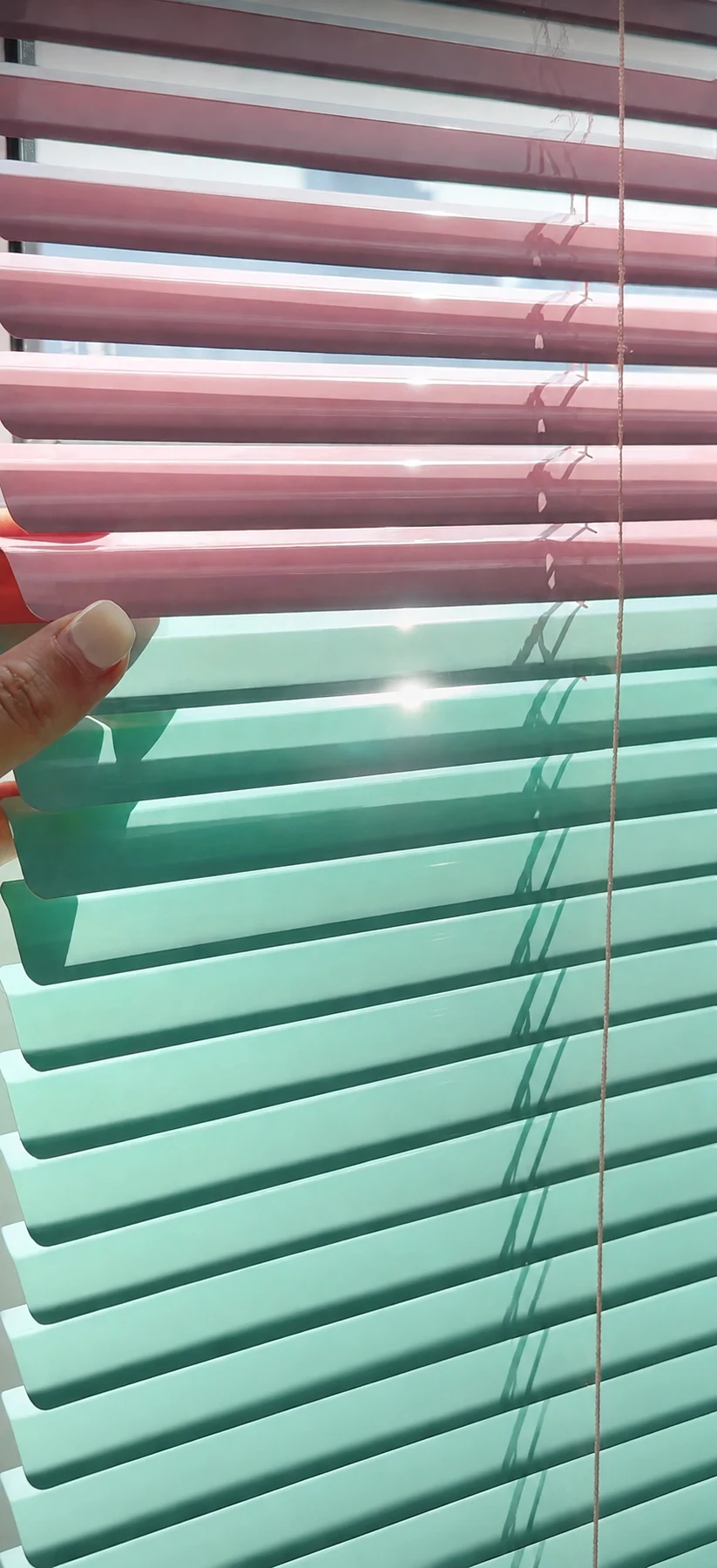 Screenshot of pink and mint narrow horizontal Venetian slats; messaging-app controls visible at bottom.